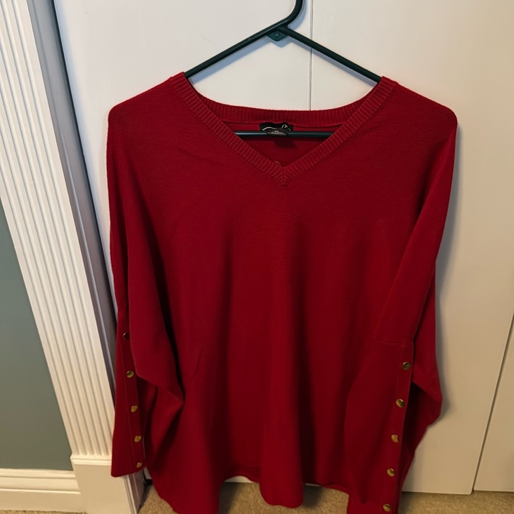 Red Vneck, tunic length sweater with detail on the bottom part of the sleeves.